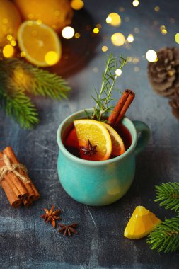 Noel baharatlı kırmızı şarap, portakal ve Noel süslemeleri karanlık masada. Mutlu bayramlar..