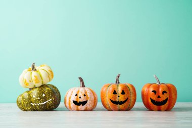 Cadılar Bayramı balkabağı jack o fener dekor ahşap masa üzerinde komik yüz mavi arka plan