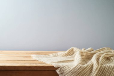 Gri arka planda modern masa örtüsü olan boş ahşap masa. Mutfak tasarım ve ürün gösterimi için hazırlandı.