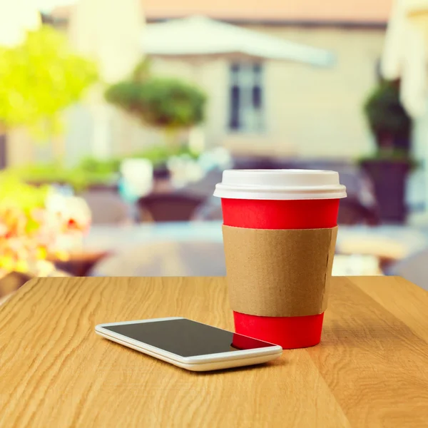 Чашка кофе и мобильный телефон — стоковое фото