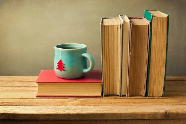 Boeken en thee beker op tafel — Stockfoto