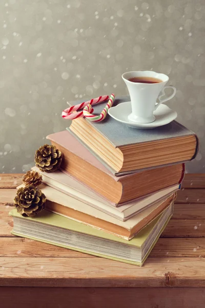 Taza de té en libros con dulces — Foto de Stock