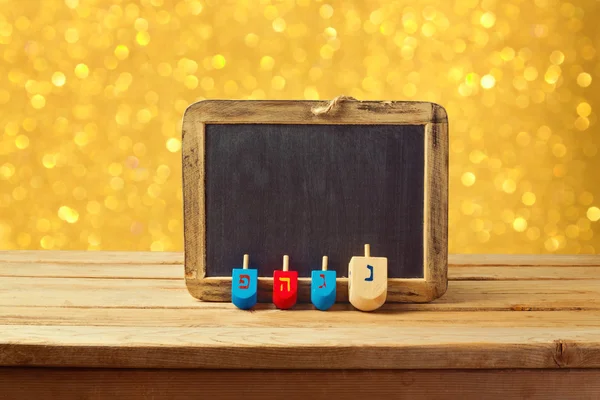 Wooden spinning top and chalkboard — Stock Photo, Image