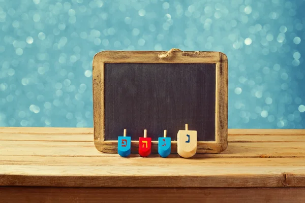 Wooden spinning top and chalkboard — Stock Photo, Image