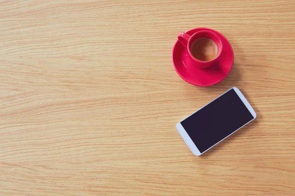 Smartphone con taza de café en la mesa — Foto de Stock