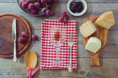 Wine, cheese and grapes on table clipart
