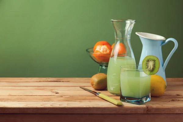 Fruit juice on wooden table — Stock Photo, Image