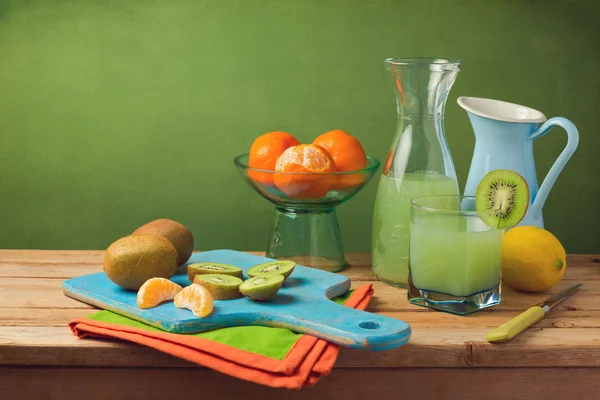 Früchte und Saft auf Holztisch — Stockfoto