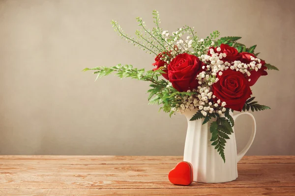 Ramo de rosas y caja de forma de corazón — Foto de Stock