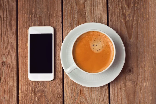Кофейная чашка и смартфон — стоковое фото