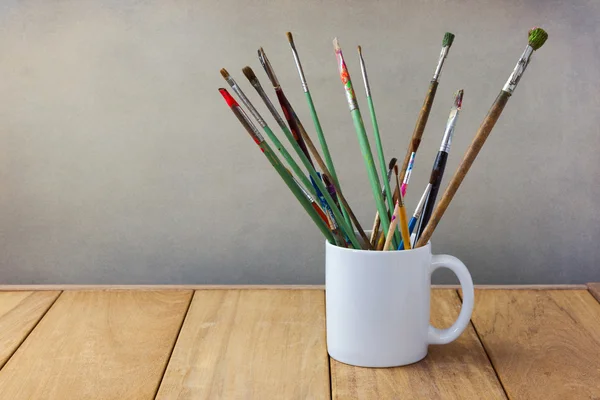 Målning penslar i vit cup — Stockfoto