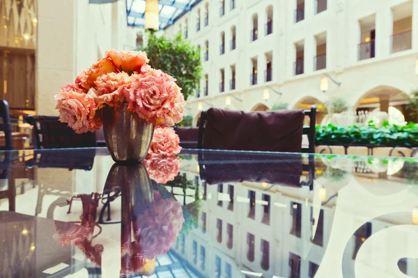 Flowers on glass table — Stock Photo, Image