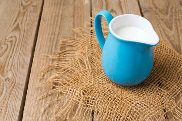 Milk jug on wooden table — Stock Photo, Image