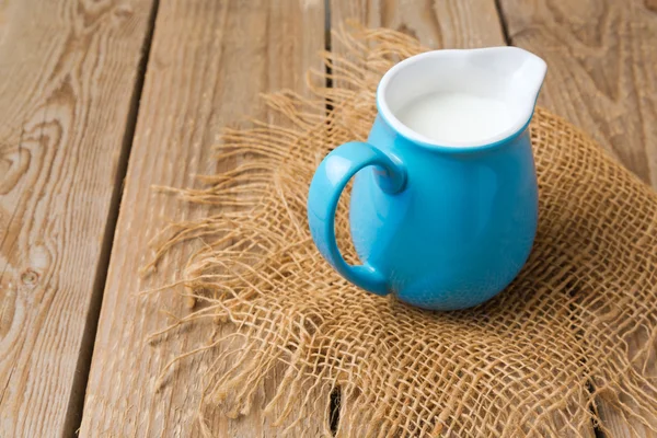 Milk jug on wooden table — Stock Photo, Image