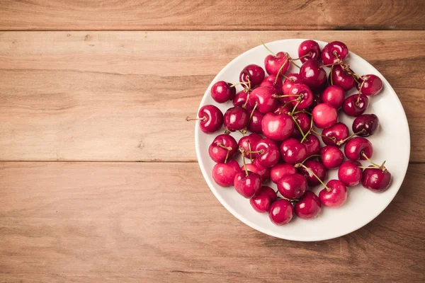 Cerezas frescas sobre mesa de madera — Foto de Stock