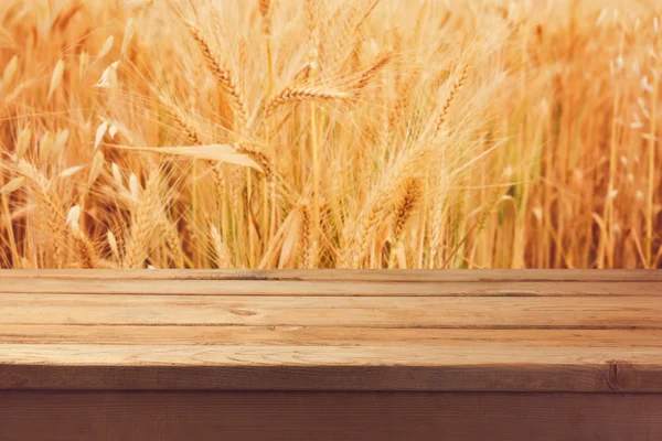 Wooden deck table over wheat field — Stock Photo, Image