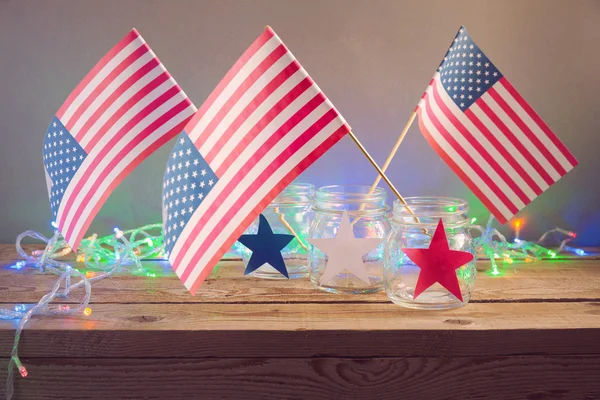 USA flags in glass jars on wooden table — Stock Photo, Image