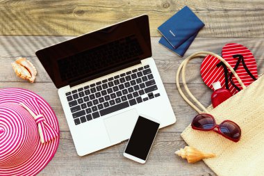 Laptop and smartphone with beach accessories