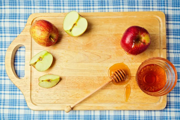 Maçã e mel em tábua de madeira — Fotografia de Stock