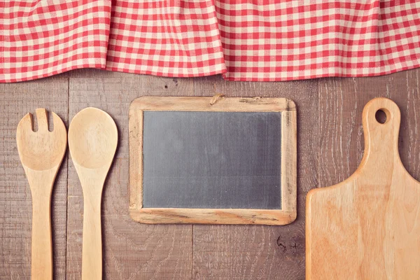 Tablecloth, chalkboard and kitchen utencils — Stock Photo, Image