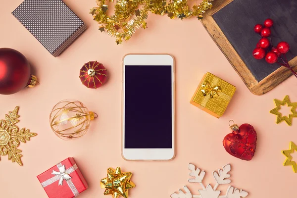 Смартфон с рождественскими украшениями — стоковое фото