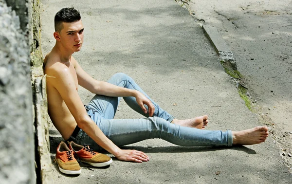 Unga trendiga killen i jeans mitt i naturen. — Stockfoto