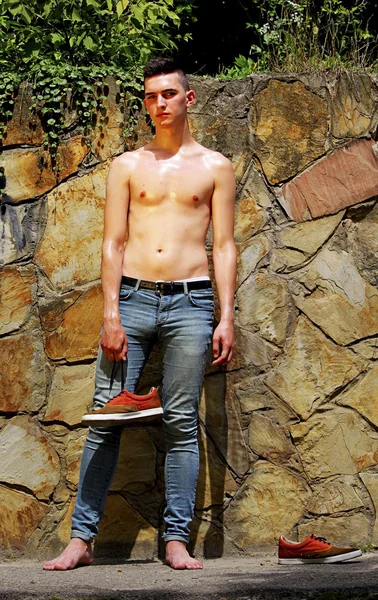 Молодой модный парень в джинсах на природе . — стоковое фото