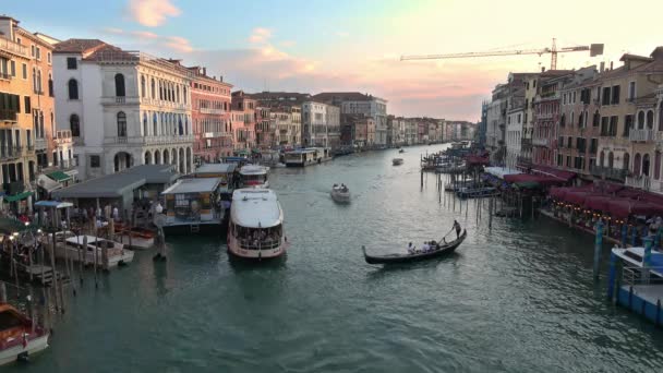ヴェネツィア 2018年7月23日 ゴンドラを操縦するゴンドラとして夕日の光の中でイタリアのヴェネツィアのグランドキャナルに沿ってリアルト橋からの広い眺め — ストック動画