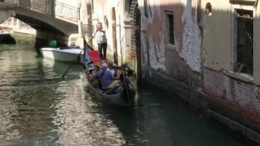 Venedik - 24 Temmuz 2018: Bir Aile Venedik, İtalya 'daki Sessiz Kanal' da Bir Gondolda Yolculuğun Tadını Çıkarsın. Sıcak ve güneşli bir günde antik Venedik binaları arasında seyahat etmek.