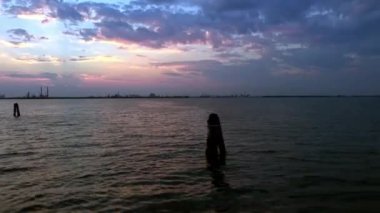 Gün batımında İtalya, Venedik yakınlarındaki sanayi kompleksinin önündeki Briccola. Hareket halindeki bir tekneden sabit atış..