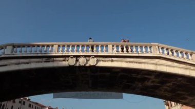 Venedik - 24 Temmuz 2018: Venedik, İtalya 'daki Scalzi Köprüsü' nün altından geçerken yukarı bakıyorum. Güneşli bir günde bir teknenin ön tarafından dengeli bir atış..