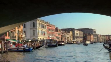 Venedik - 24 Temmuz 2018: Büyük Kanal, Venedik, İtalya 'da Rialto Köprüsü' nün altından geçerken yavaş çekim. Hareket halindeki bir teknenin önünden sabit atış..