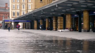 19 Mart 2020: Coronavirus salgını sırasında King 's Cross Tren İstasyonu' nun olağandışı sessiz girişinin önünde evsiz insanlar ve bir ya da iki kişi.