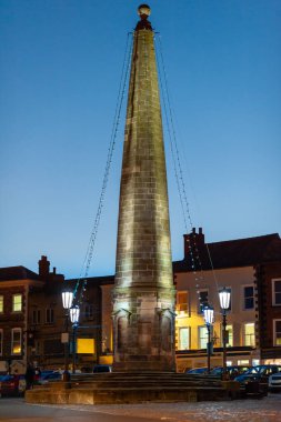 Richmond Market Place 'deki Obelisk, Kuzey Yorkshire' da akşam saatlerinin ışıltısında arka planda masmavi gökyüzü vardı..
