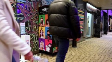 Londra, Carnaby Caddesi 'nde maske otomatının yanında el dezenfektanı kaidesi kullanıyor.