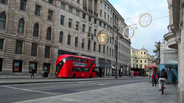 LONDÝN - 3. listopadu 2020: Vánoční dekorace světla nad Red London Double Decker autobus jako chodci procházka kolem na Strand, Londýn