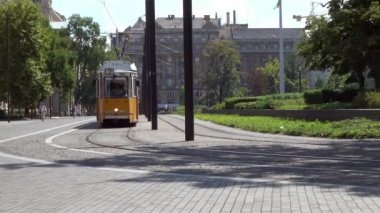 BUDAPEST - Macaristan 'ın Budapeşte kentindeki Kossuth Lajos Meydanı' nda güneşli bir günde bir tramvayın virajda dolaşmasının ardından yakınlaştırma çekimi.