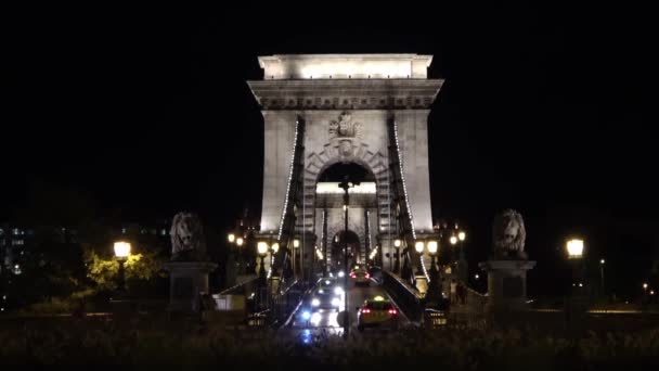 Budapest 2018年8月21日 ハンガリー ブダペストのThe Chain Bridgeでの深夜交通 橋の中央にはライオン像が左右に並んでいる — ストック動画