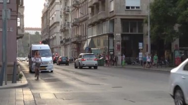 BUDAPEST - 21 AĞUSTOS 2018: Bir yaz akşamı Macaristan 'ın başkenti Budapeşte' de bisiklet sürerken akıllı telefondan konuşan güzel genç kadın.