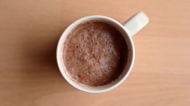 Şekerlemeler bir fincan sıcak çikolataya eklenirken yukarıdan aşağı doğru yavaş hareket.