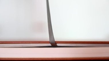 KAPALI KAPALI KAPALI Deri kaplı bir kitabın kitap kurdele işaretini çekerek açıldığı sığ odak noktasına odaklan.