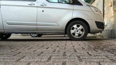 Richmond, Kuzey Yorkshire, İngiltere - 21 Haziran 2020: Arka planda park etmiş bir minibüsle bir aracın ön tekerleğini ileri doğru sürerken kapatın