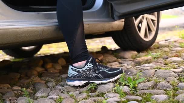 2020年6月21日イギリス ノースヨークシャー州リッチモンド 石畳の地面から車や車のドアに運動用の衣類リフトを身に着けている足と脚が閉まります — ストック動画