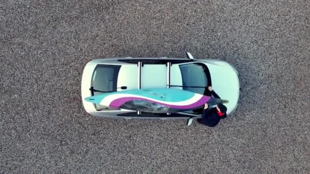 Top Aerial Drone Shot Man Loads Slalom Kayak Roof Rack — Stock Video