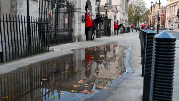 ロンドン 2020年11月3日 ホースガードパレードの入り口に 騎兵隊と警視庁の騎馬警官が待機している 地面の水たまりの反射 — ストック動画