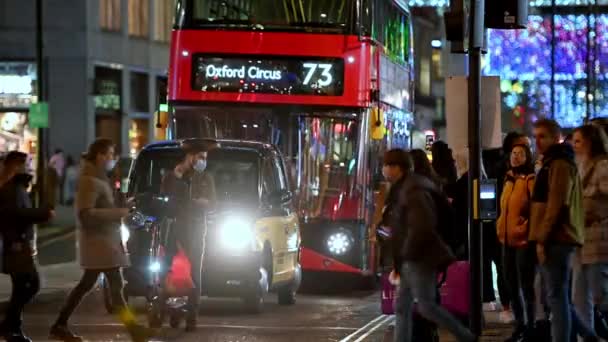 2020年11月3日 一辆电动车上戴着Ppe面罩的男子在伦敦牛津街圣诞灯饰下繁忙的红绿灯前停下 — 图库视频影像