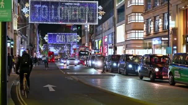 2020年11月3日 牛津街圣诞装饰品下繁忙的夜晚交通场面 前面有一个科维德19号社交路标 — 图库视频影像