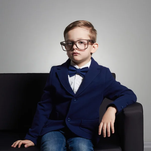 Niño pequeño en traje y glasses.stylish niño en la silla —  Fotos de Stock