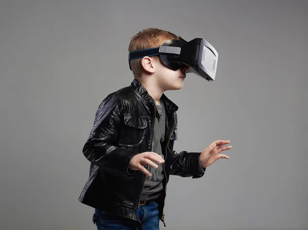 little Boy in virtual reality glasses playing the game. 3D VR glasses