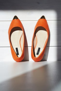 female summer shoe on wooden background.orange girls shoes without heels clipart